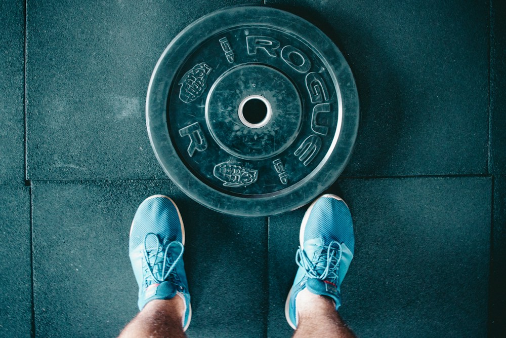 Training shoes beside a weight plate on the gym floor